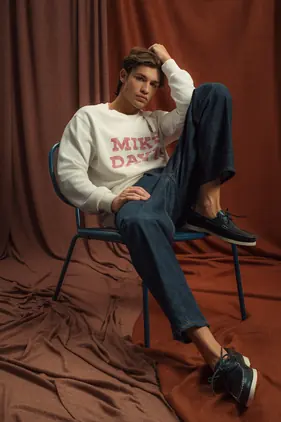 Rapaz sentado com sweatshirt branca MIKE DAVIS